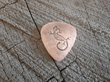 copper guitar pick with lizard