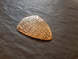bronze shield haped guitar pick with pattern - playable
