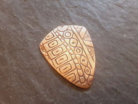 bronze shield haped guitar pick with pattern - playable