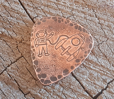 copper guitar pick with astronaut