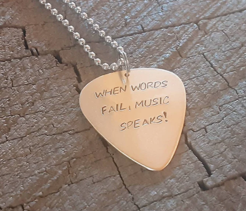bronze guitar pick necklace with when words fail, music speaks