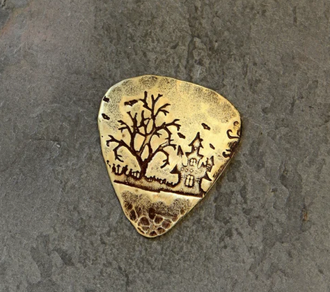 brass guitar pick - haunted house