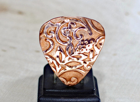 Rococo copper guitar pick with asymmetrical vine design