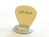 Brass guitar pick with Let’s Pluck