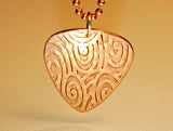 Copper guitar pick necklace with swirling waves of sound