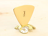 Triangular bronze bass guitar pick with musical inspiration