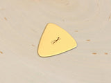 Triangular bronze bass guitar pick with musical inspiration