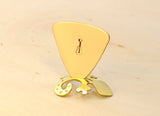 Triangular bronze bass guitar pick with musical inspiration