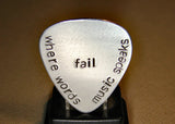 Stamped aluminum guitar pick where words fail music speaks