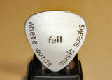 Stamped aluminum guitar pick where words fail music speaks